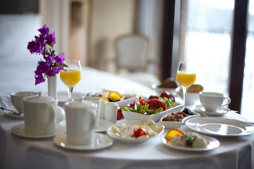 a table topped with plates of food and glasses of orange juice at Marti Hemithea Hotel in Orhaniye