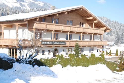 een groot houten gebouw met sneeuw erop bij Sportpension Christina by PiaundDirk in Fügen