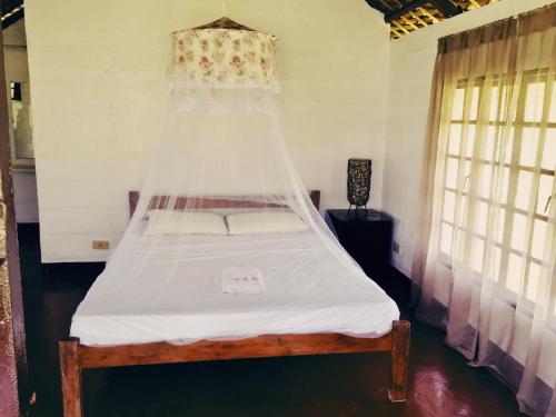 a bed with a net over it in a room at Viento de Mar in Gindi