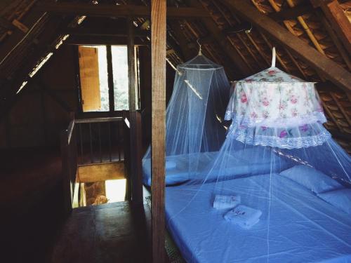 a room with a blue bed with a canopy at Viento de Mar in Gindi
