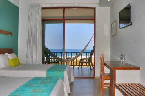 a bedroom with a bed and a view of the ocean at Punta Zicatela Hotel - Adults Only in Puerto Escondido