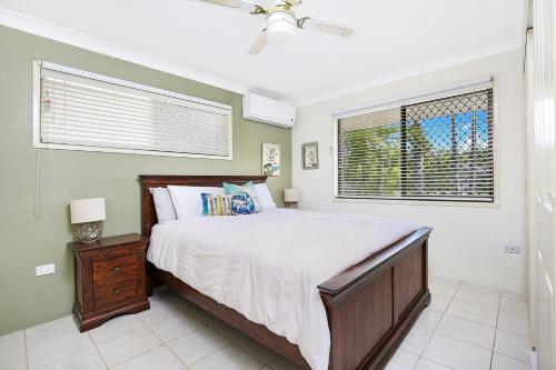 ein Schlafzimmer mit einem großen Bett und einem Fenster in der Unterkunft Michael Street 39 Golden Beach in Caloundra