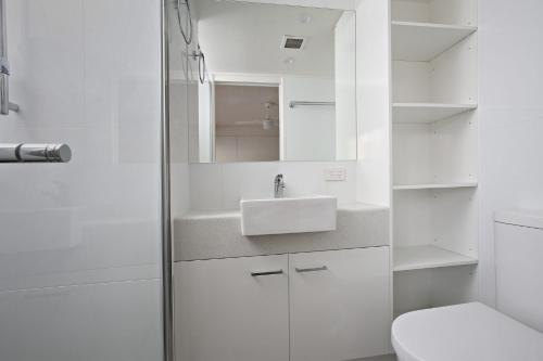 a white bathroom with a sink and a toilet at Edmund Shores U5 58 Edmund Street in Caloundra