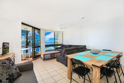 a living room with a table and a couch at Eastbourne U4 80 Esplanade Golden Beach in Caloundra