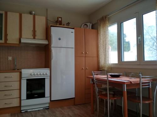 een keuken met een tafel en een witte koelkast bij Seaside Studio in Salamis