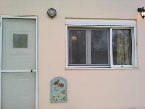 una puerta y una ventana en el lateral de una casa en Seaside Studio, en Salamina