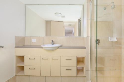 uma casa de banho com um lavatório e um chuveiro em Seabourn Unit 102, 56 Lower Gay Tce Caloundra em Caloundra
