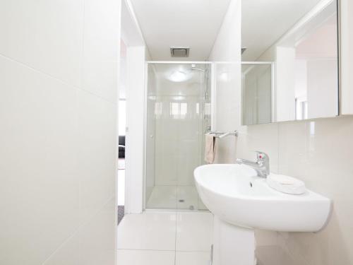 a white bathroom with a sink and a shower at Pacific Towers Unit 4 19 Ormonde Tce Kings Beach in Caloundra