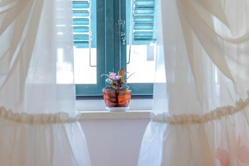 a vase with flowers sitting on a window sill at Studio Stradun in Dubrovnik