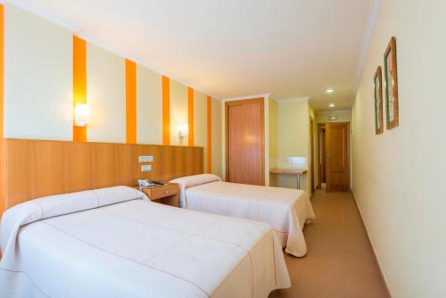 a hotel room with two beds and a hallway at Hotel O Cruceiro in Caldas de Reis