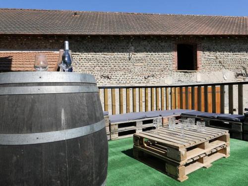 un patio con 2 barriles de vino y una mesa en Domaine Lacay, en Beyrie-en-Béarn