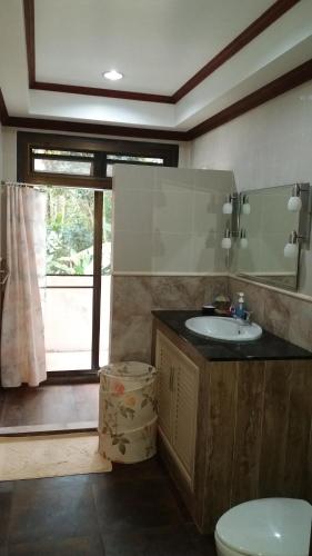 Un baño con lavabo, inodoro y espejo. en Periwinkle Villa, en Ko Chang