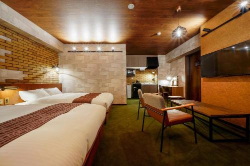 une chambre d'hôtel avec deux lits et une cuisine dans l'établissement RESI STAY BRiX, à Kyoto