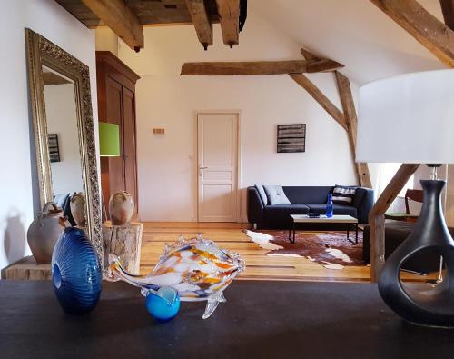 a living room with a couch and a mirror at Moulin Renaudiots - Maison d'hôtes in Autun