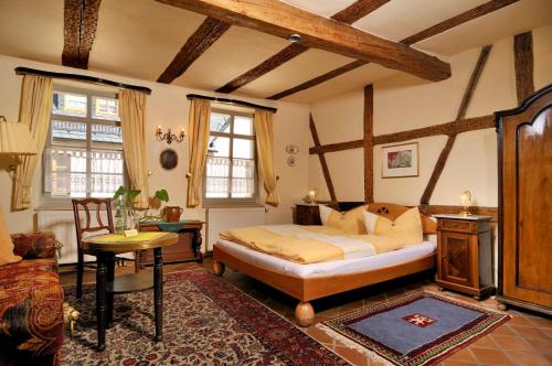 a bedroom with a bed and a table in a room at Matsch - Plauens älteste Gastwirtschaft in Plauen