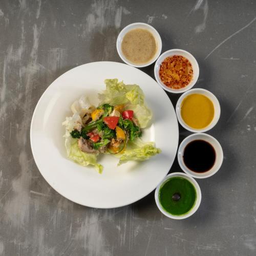 a white plate of food with vegetables and other ingredients at Modi Yoga Retreat Rishikesh in Rishīkesh