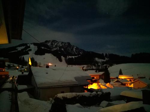 a night view of a town with a snow covered mountain at Jungholz Erlebnis in Jungholz