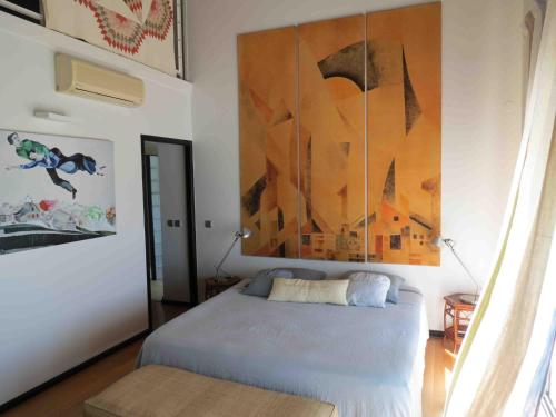 a bedroom with a bed and a painting on the wall at Villa 'Florence' avec longue piscine et vue mer panoramique in Saint-Gilles les Bains
