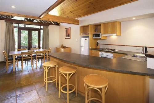 a kitchen with a large counter with stools in it at Margaret River Resort in Margaret River Town