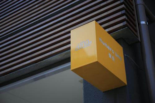a yellow sign on the side of a building at Numero Uno Tokyo in Tokyo