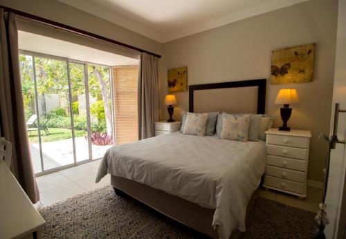 1 dormitorio con cama y ventana grande en House on Olof Palme en Windhoek