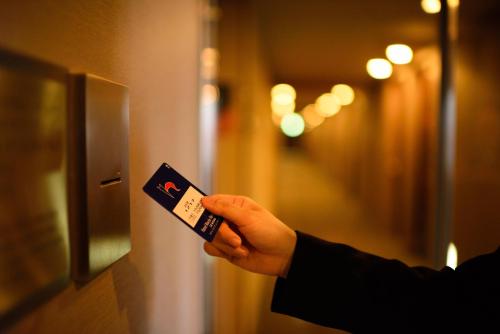 a person holding a card in their hand at Hotel Monte Hermana Sendai in Sendai