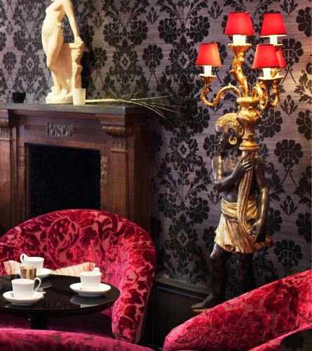 a living room with a table and a lamp and a chair at Dorsia Hotel & Restaurant in Gothenburg