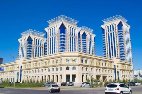 a large building with cars parked in front of it at Однокомнатная квартира в ЖК Millennium Park in Astana