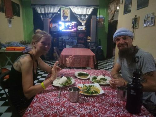 a man and a woman sitting at a table with plates of food at Mulu D cave homestay in Mulu