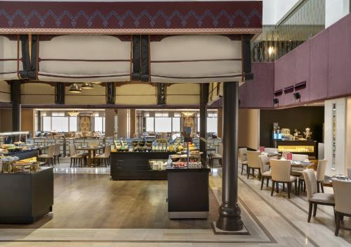 uma sala de jantar com mesas e cadeiras e um restaurante em Barceló Istanbul em Istambul
