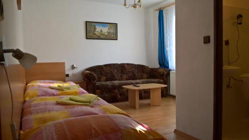 a bedroom with a bed and a couch and a table at Penzion Kalina in Tábor