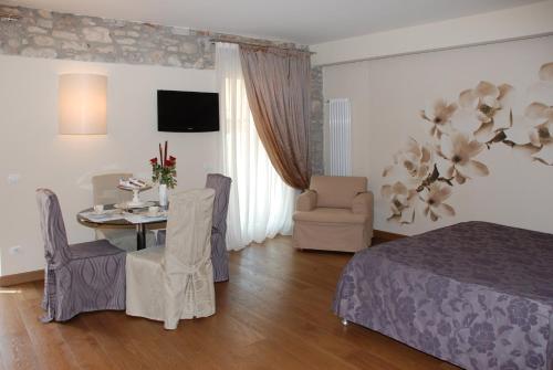 a bedroom with a bed and a table and chairs at Oreste Suite in Lazise