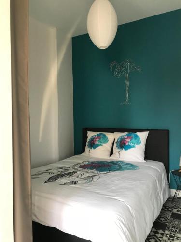 - une chambre dotée d'un lit avec un mur vert dans l'établissement F2 41m2 Metz Hyper-centre, à Metz