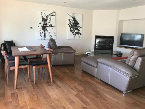 a living room with couches and a table and a television at Hakuba West Coast Inn, Villa in Hakuba