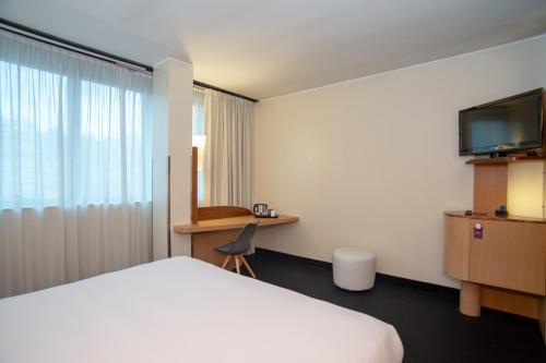 Ένα ή περισσότερα κρεβάτια σε δωμάτιο στο Mercure Roma West