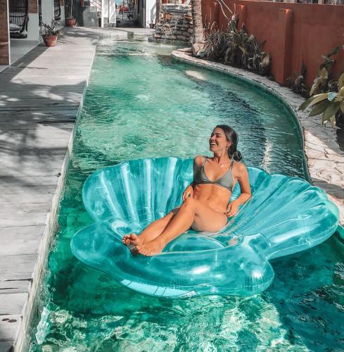 a woman in a bikini sitting on an inflatableinylinyl at Pesona Beach Resort & Spa - Adults Only in Gili Trawangan
