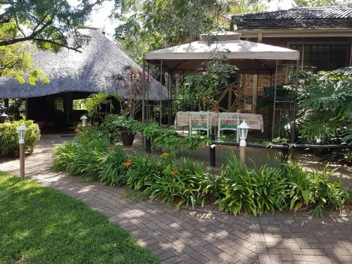 a garden with two chairs and a pavilion at Shingalana Guest Lodge in Hazyview