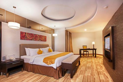 a hotel room with a large bed and a television at ASTON Pontianak Hotel and Convention Center in Pontianak