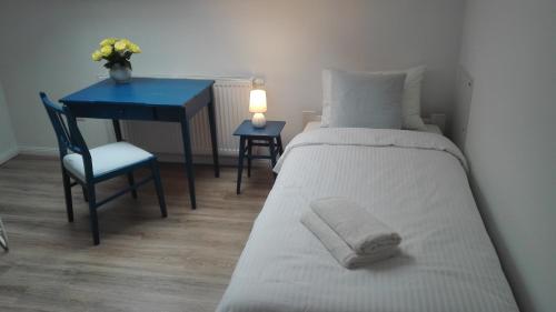 a bedroom with a bed and a desk with a lamp at Zacisze Kalwy in Kalwy