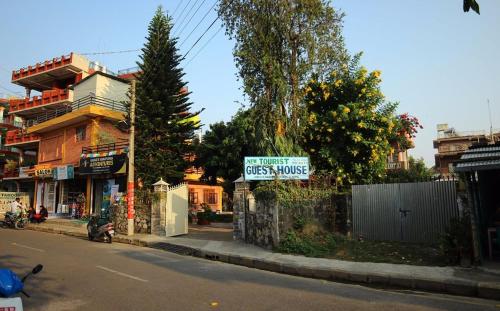 un panneau sur le côté d'une rue dans l'établissement New Tourist Guest House, à Pokhara