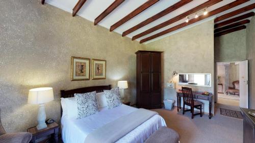 a bedroom with a bed and a desk and a chair at Ancient Emperor Guest Estate in Potchefstroom