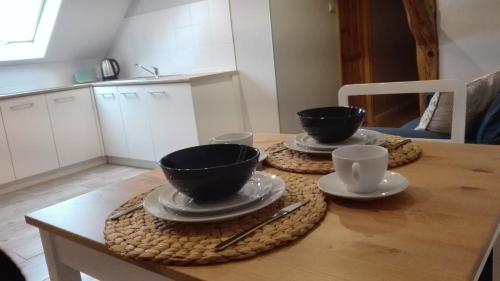two cups and saucers on a table in a kitchen at Zacisze Kalwy in Kalwy
