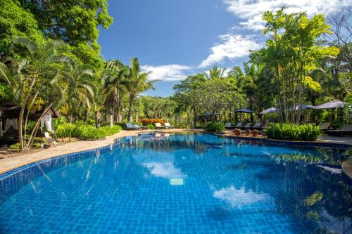 - une piscine dans un complexe avec des arbres en arrière-plan dans l'établissement Annika Koh Chang , Formerly Ramayana Koh Chang Resort & Spa, à Ko Chang