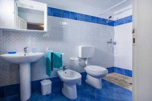 un bagno bianco e blu con servizi igienici e lavandino di Ampio monolocale al mare nel Salento Ionio m604 a Torre Vado