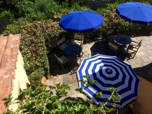 two blue and white umbrellas and tables and chairs at Agriturismo La Palazzina in Palaia