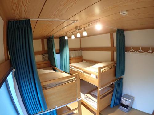 Zimmer mit 2 Etagenbetten und einem Fenster in der Unterkunft Guesthouse SORA in Minamiizu