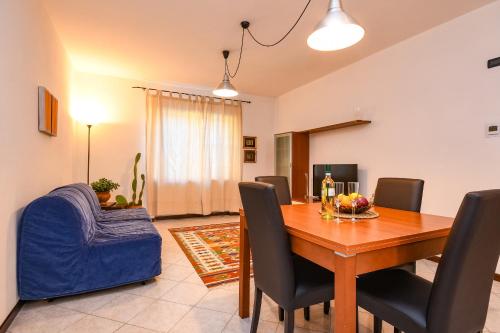 een eetkamer met een tafel en een blauwe bank bij DesenzanoLoft Yellow Apartment in Desenzano del Garda