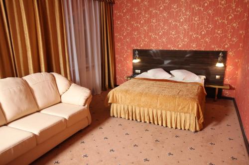 a hotel room with a bed and a couch at Hotel Imperia in Tula