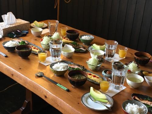 een houten tafel met borden met eten erop bij Pension Kinouta in Biei