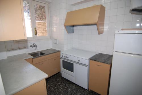 uma cozinha com um frigorífico branco e um lavatório em Alexis Basic em Salou